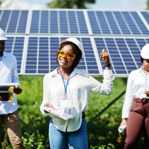African american technician checks the maintenance of the solar panels. Group of three black engineers meeting at solar station.